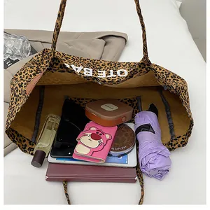 Detailed top view of a large leopard print tote bag showing spacious interior with daily items