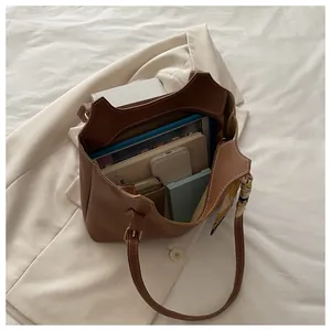 Spacious brown tote bag interior with organized items and silk scarf detail