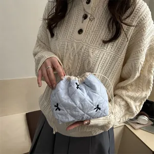 Quilted light blue drawstring pouch with elegant black bow embroidery for daily storage