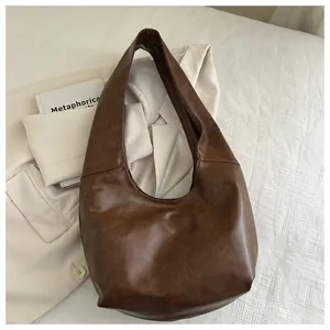 Dettaglio borsa hobo marrone scuro testurizzata vintage con ampia tracolla integrata