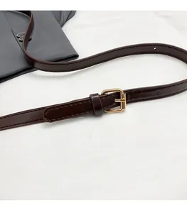 Close-up of adjustable deep brown leather shoulder strap with golden metal buckle hardware