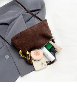 Macro view of spacious suede interior with metal chain accent and various cosmetics