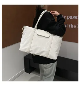 Back view of a person carrying a stylish large white crinkled travel tote bag