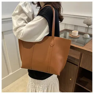 Detalle del bolso tote marrón grande con asas finas y costuras de precisión