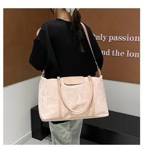 Pink travel bag detail featuring pleated fabric texture and leather reinforced handles