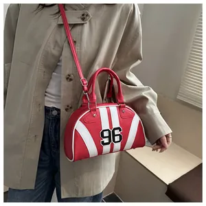 Détail du sac à main demi-rond rouge avec rayures blanches et broderie 96 en bandoulière