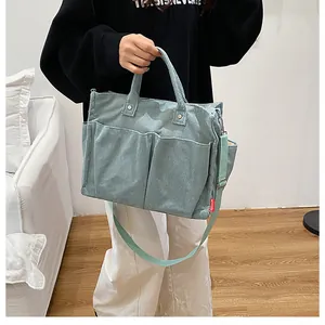 Dettaglio della borsa tote in velluto a coste verde menta con tracolla e tasche esterne