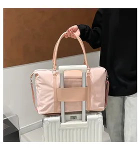 Pink travel bag with luggage sleeve attachment on suitcase handle for easy mobility