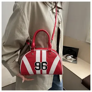 Détail du sac bandoulière rayé rouge et blanc avec motif 96 et clous étoiles
