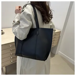 Detalle macro de la bolsa tote minimalista de cuero negro con elegantes costuras