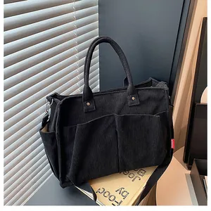 Dettaglio della borsa tote in velluto nero con ampie tasche e trama del tessuto