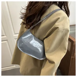 Glossy grey patent leather shoulder bag detail with elegant gold metal hardware buckle