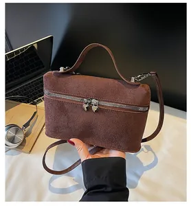 Details der kaffeebraunen Wildledertasche mit silbernen Reißverschlüssen in Herzform