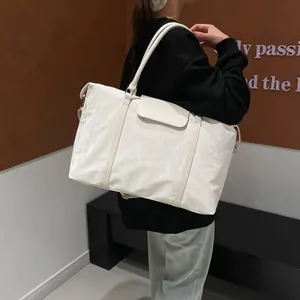 Minimalist cream white quilted nylon travel bag with adjustable strap in back view