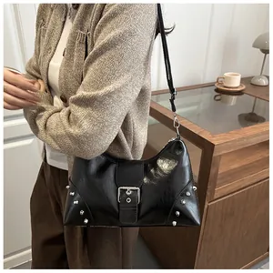 Detail der schwarzen Y2K-Schultertasche mit silbernen Nieten und Schnalle im Lifestyle-Stil