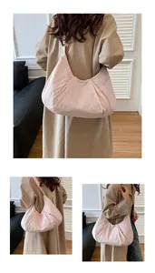 Detail view of large light pink pleated dumpling bag with smooth glossy nylon fabric