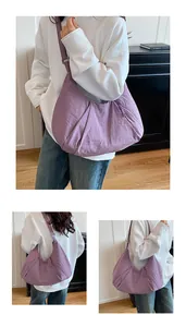 Detail of purple nylon crescent bag featuring pleated texture and adjustable strap