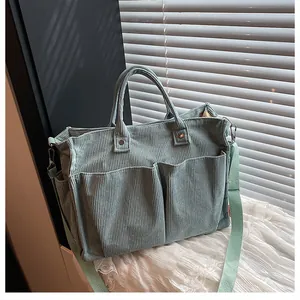 Dettaglio borsa tote in velluto a coste verde menta con doppie tasche anteriori