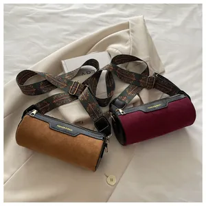 Detailansicht der Zylindertasche mit mattiertem Leder und gewebtem Schultergurt