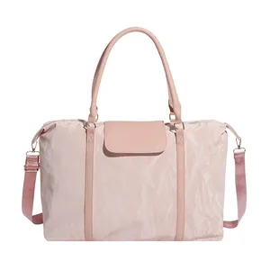 Pink quilted travel bag with top handles and adjustable shoulder strap in a minimalist style
