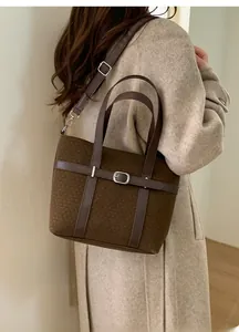 Détail du sac seau marron vintage avec lanières en cuir et boucles métalliques argentées