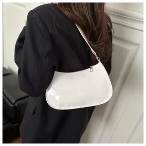 Model view of a glossy white half-moon hobo bag with gold zipper and smooth patent finish