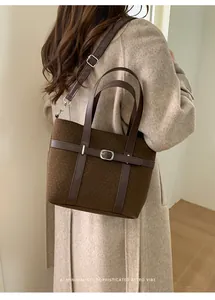 Détail du sac seau marron vintage avec lanières en cuir et boucle argentée ajustable
