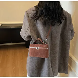 Close-up of heart zipper detail on brown matte box bag with minimalist leather finish