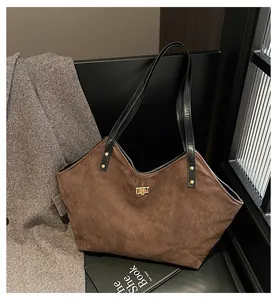 Macro detail of large brown quilted tote bag with golden twist lock and rivet hardware