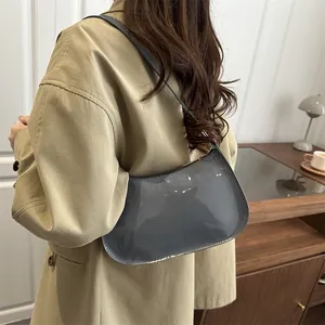 Chic grey patent leather half-moon shoulder bag styled with an oversized khaki blazer