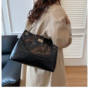 Détail du sac cabas matelassé noir avec chaîne dorée et fermeture à boucle