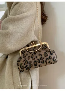 Dettaglio borsa a guscio leopardata con chiusura in metallo dorato e tracolla