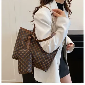 Dettaglio della borsa tote marrone scuro con motivo a stelle dorate e pochette abbinata