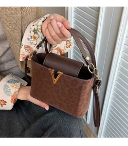 Détails du sac à bandoulière marron foncé à motif léopard et fermoir doré en V