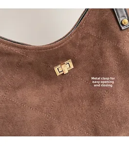 Detail of dark brown quilted suede tote bag featuring a golden rectangular twist lock