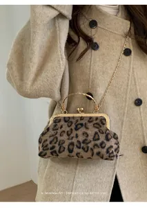 Modella con borsa a conchiglia leopardata retrò con manico dorato e tracolla a catena