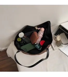 Internal view showing large storage capacity of a brown suede tote bag with essentials