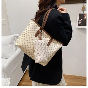 Dettaglio di una borsa shopper a motivi con pochette coordinata indossata da modella