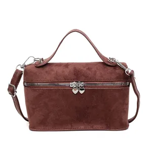 Minimalist brown suede box-style handbag with heart-shaped zippers and crossbody strap