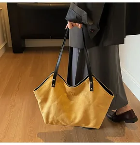 Detail of yellow quilted tote bag featuring gold metal twist lock and durable black handles