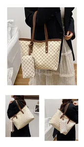 Dettaglio della borsa shopper e della pochette coordinata con motivo a trifoglio marrone su crema