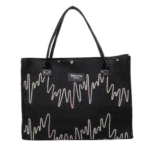 Grand sac cabas noir avec broderie ondulée colorée et étiquette de marque tendance