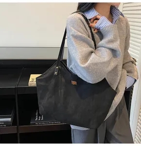 Detail of black matte tote bag with golden twist lock and long double shoulder straps