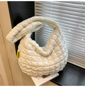 Détail du sac cabas matelassé blanc montrant sa texture douce et son étiquette mode