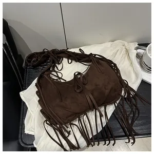 Détail du sac à bandoulière demi-lune en daim marron foncé avec de longues franges bohèmes