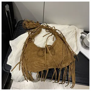 Détail du sac croissant en daim marron avec franges bohèmes et texture cuir souple