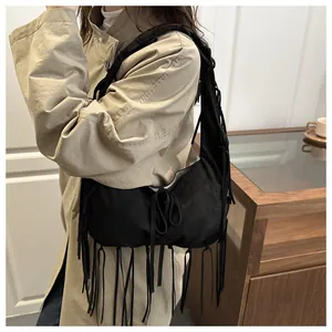 Détail du sac hobo en daim noir avec de longues franges de style bohème vintage