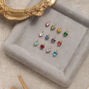 Macro view of twelve colorful heart-shaped zirconia pendants with 18K gold plated clasps