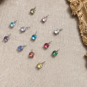 Close-up of colorful round zirconia charms with silver prong setting and hanging loops