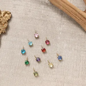 Macro shot of colorful round cubic zirconia pendants with gold claw settings in ten vivid colors